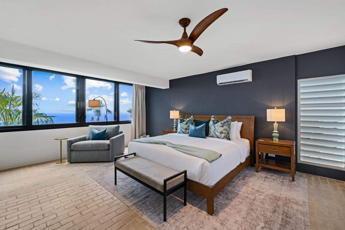 Comfortable king bed with twin sleeper sofa, ceiling fan, air conditioner, blackout curtains, smart TV, make up table, and ensuite bathroom.