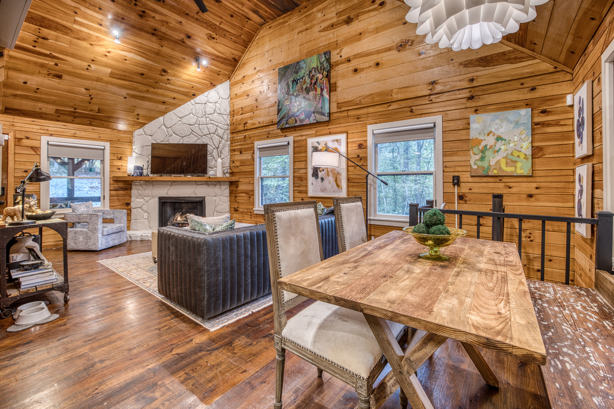 Dining table with a pendant light and living room beyond.