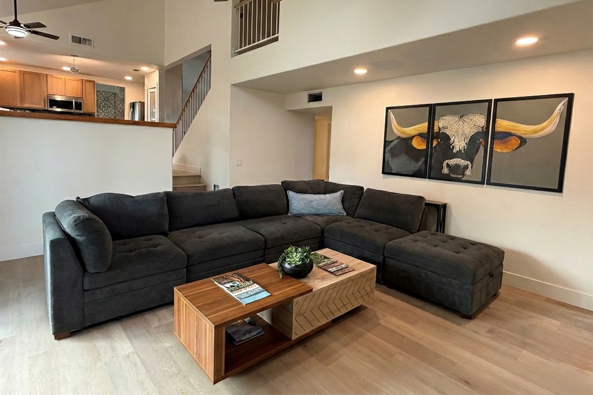 Large living room with a ton of seating & big screen smart TV