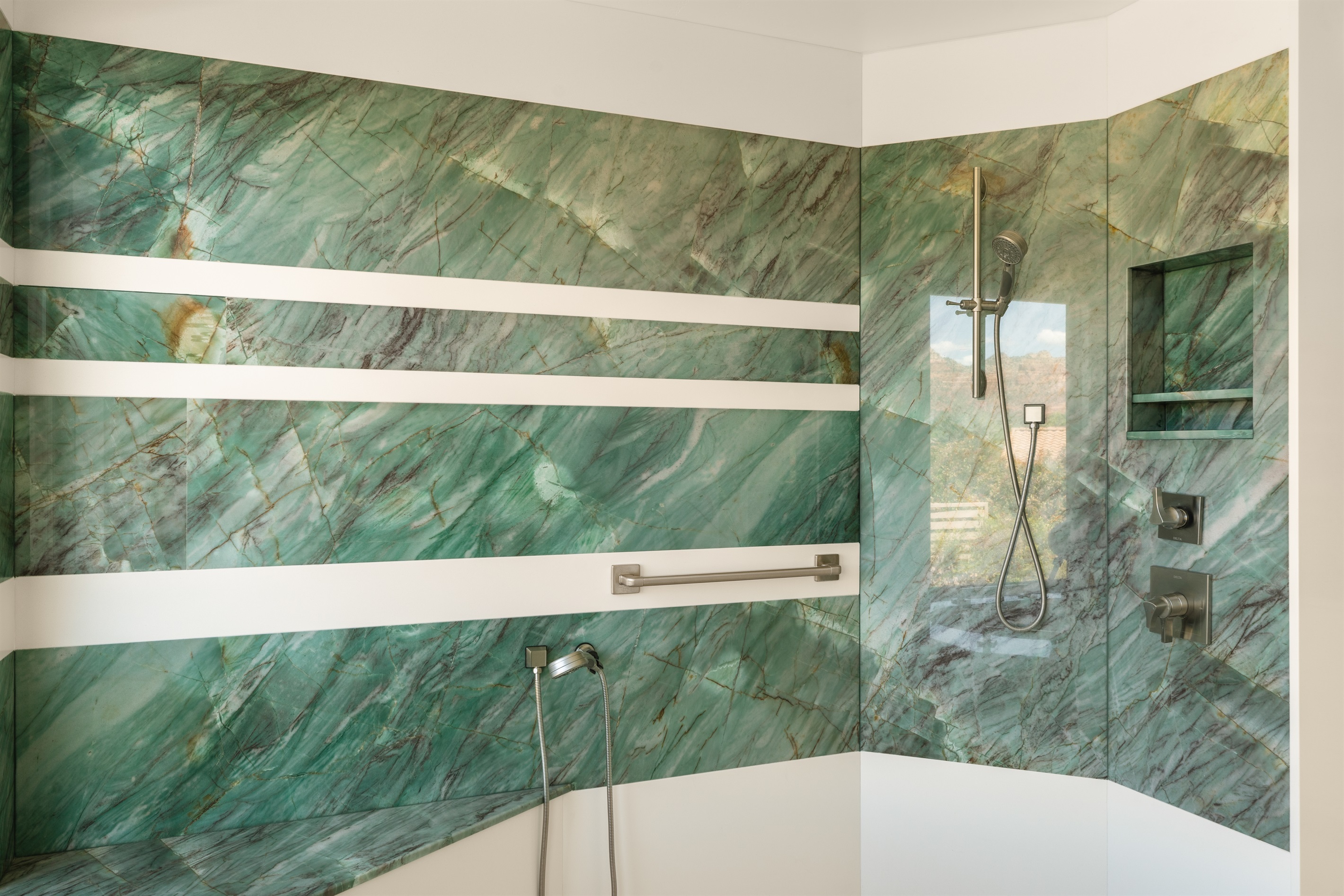 Rinse off the desert dust in our massive walk-in shower, featuring stunning floor-to-ceiling green marble, multiple showerheads, and premium Delta fixtures.