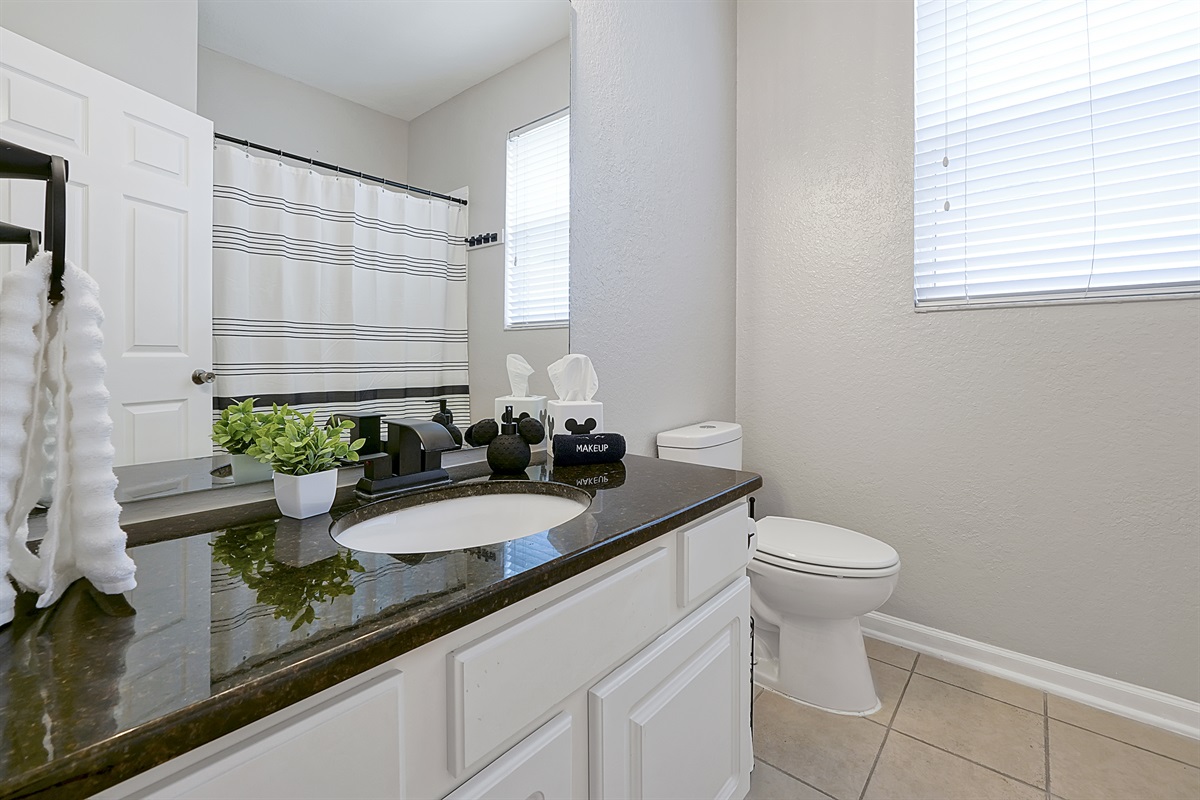 The downstairs shared full bathroom also serves as the Beauty and the Beast&rsquo;s dedicated bath. The classic Mickey Mouse decor found in the kitchen and family room weaves seamlessly into this shared space.