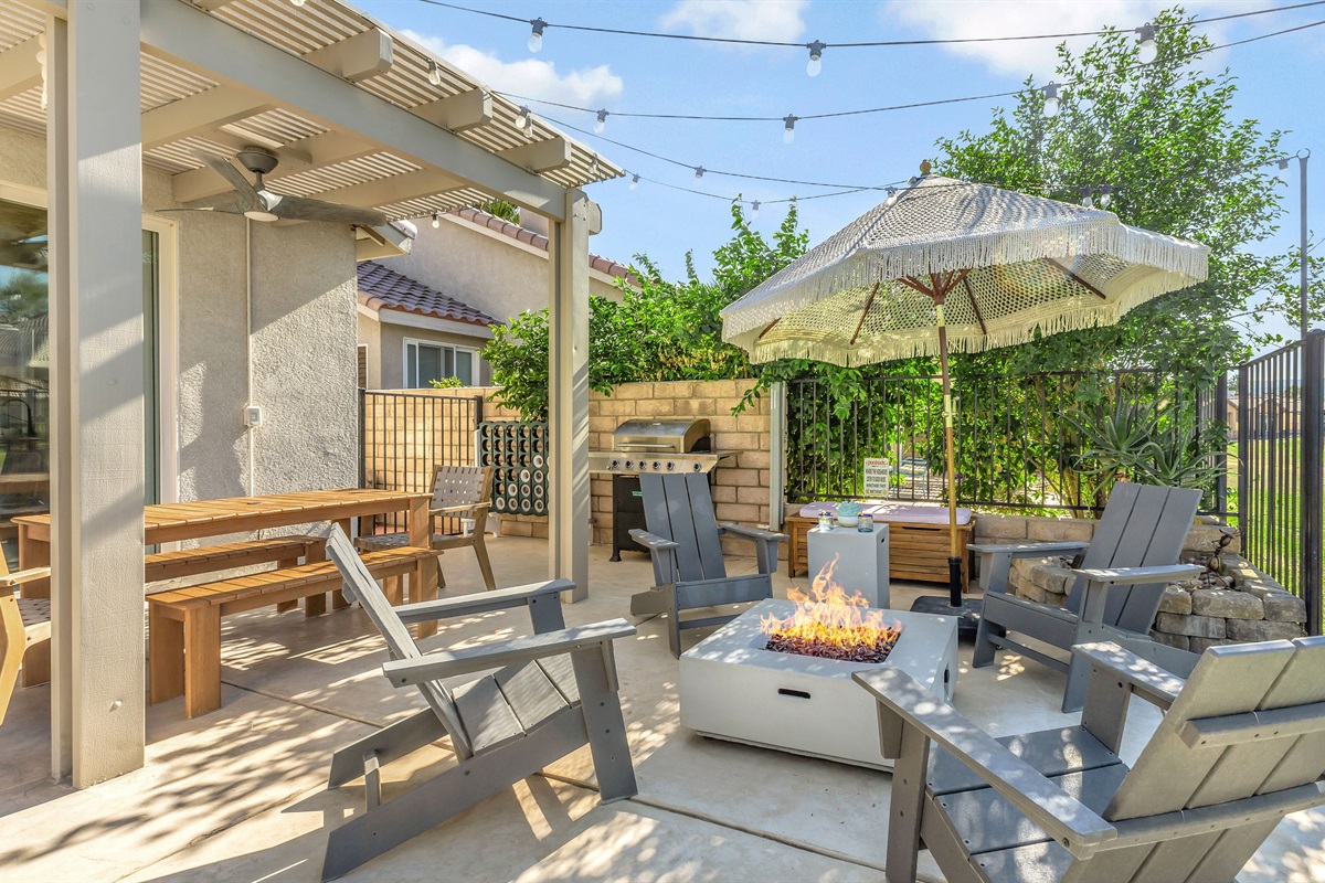 ✨  Patio Dining & BBQ Area  Covered outdoor dining area with a BBQ grill and string lights—ideal for casual meals or sunset dinners under the pergola.