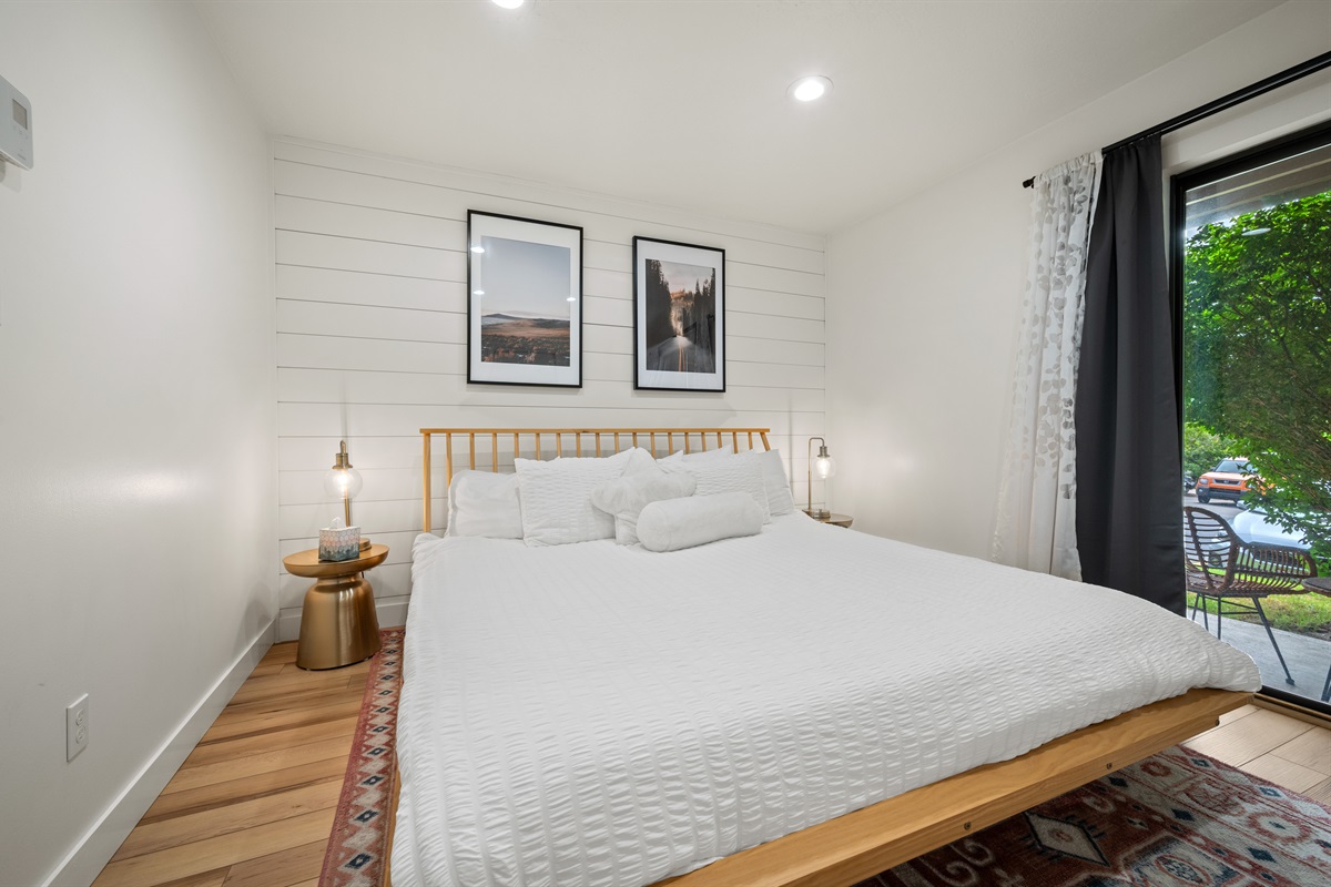 The bedroom is outfitted with a queen bed, luxurious linens, and plush pillows.