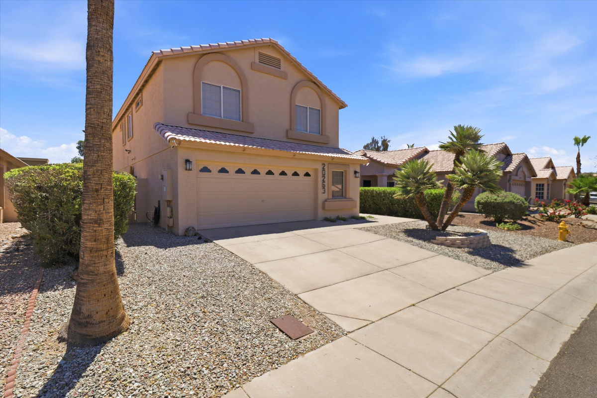  Front exterior with garage, driveway parking, desert landscaping, and a clean neighborhood arrival view.