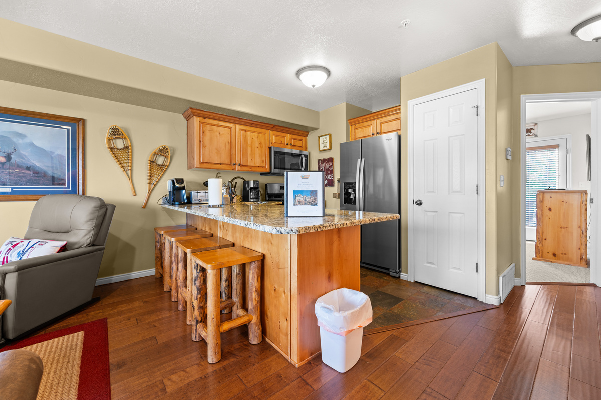 The gourmet kitchen features breakfast bar with seating for four and is equipped with appliances, including a microwave, gas stove, and spacious refrigerator.
