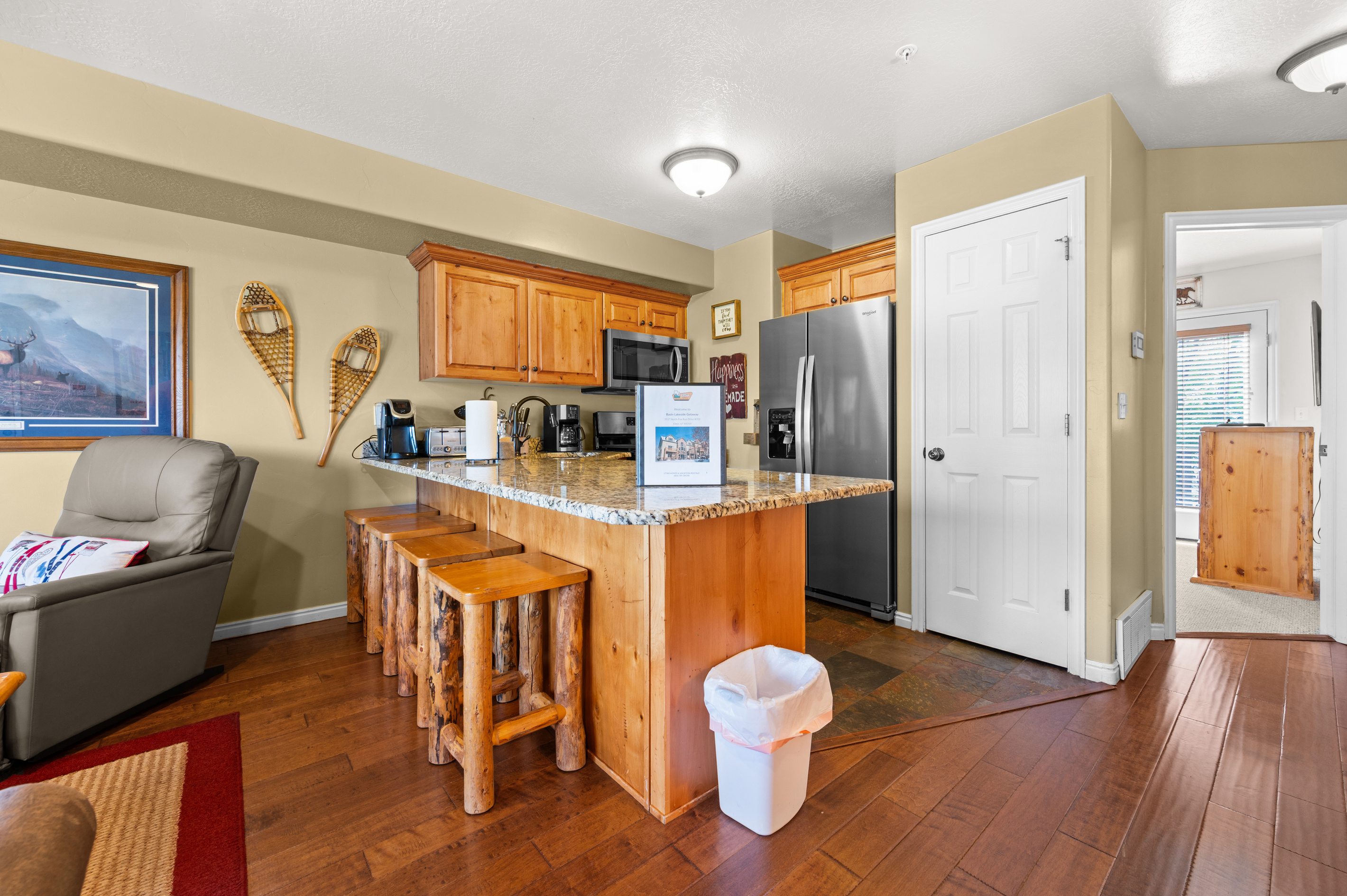 The gourmet kitchen features breakfast bar with seating for four and is equipped with appliances, including a microwave, gas stove, and spacious refrigerator.
