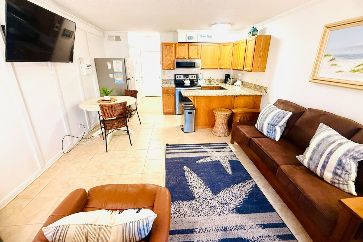 Living room with leather sofa, open to the kitchen