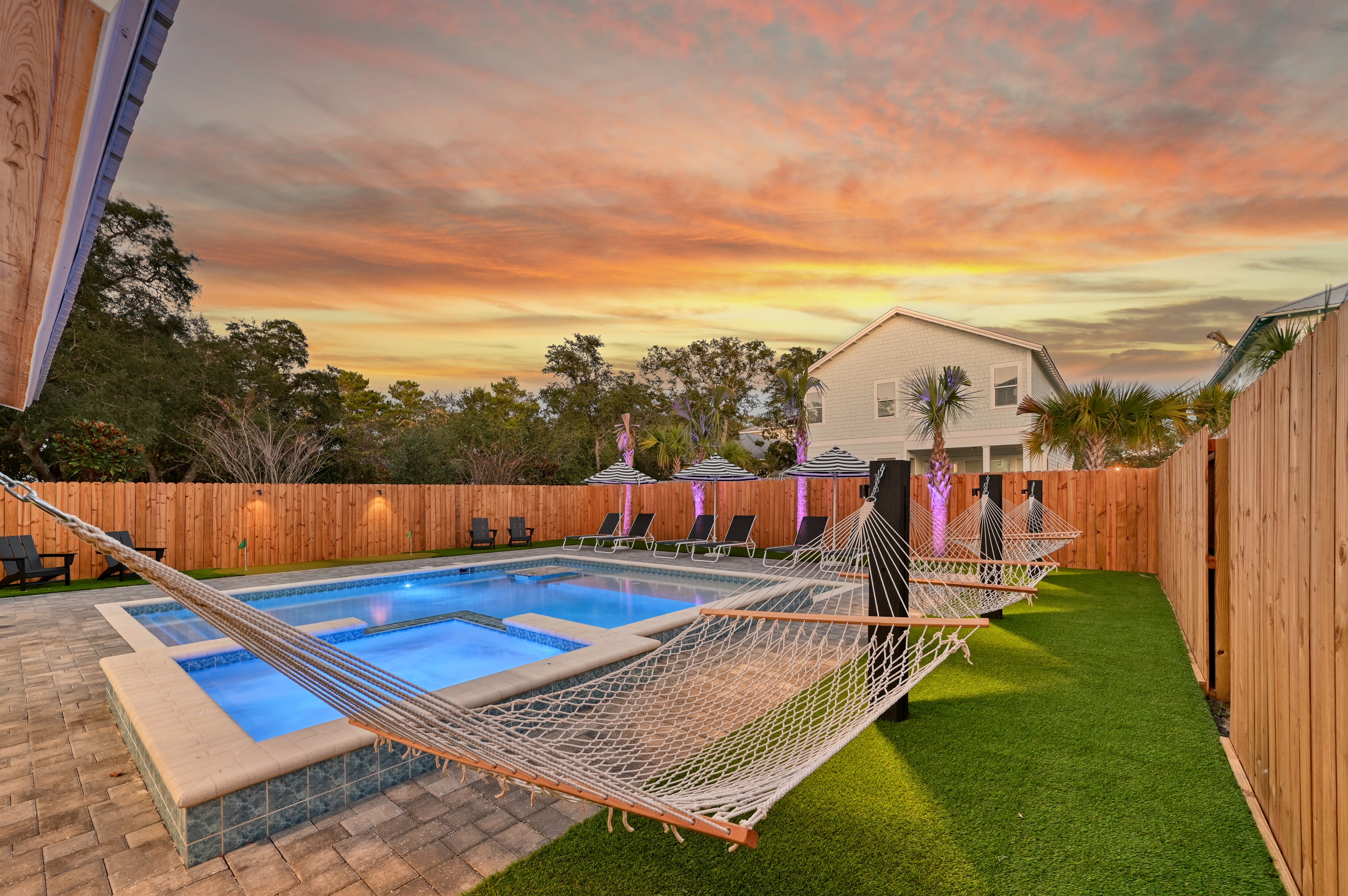 Landscape lighting at sunset and poolside hammocks
