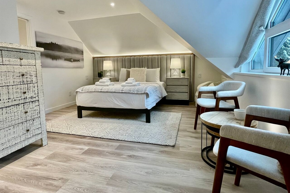 Master Bedroom#1 w/ ensuite bathroom is spacious, bright & features a seating area overlooking Fitzsimmons Creek & Whistler Mountain. Luxuries Incl: Integrated A/C & radiant floor heating, LED accent lighting, & bedside USB power outlets 