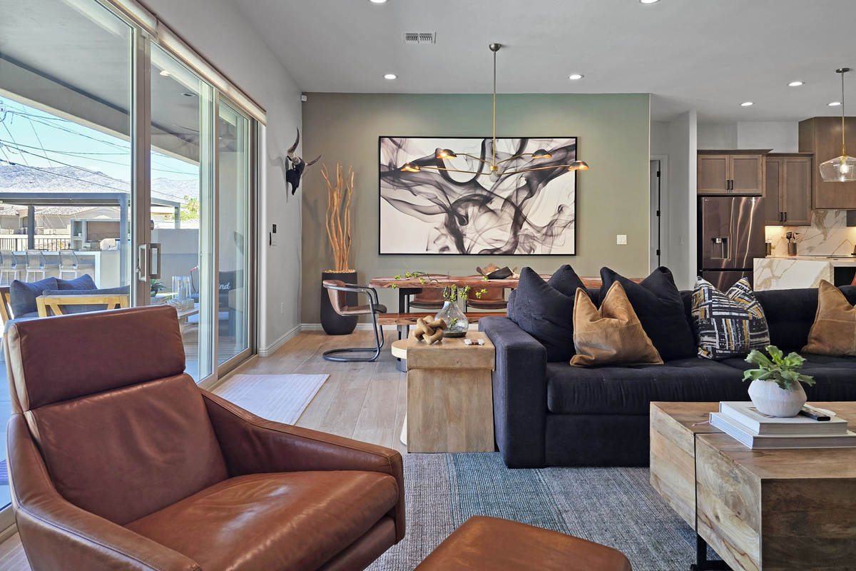 The living room flows seamlessly onto the outdoor patio, creating an effortless indoor-outdoor living experience.