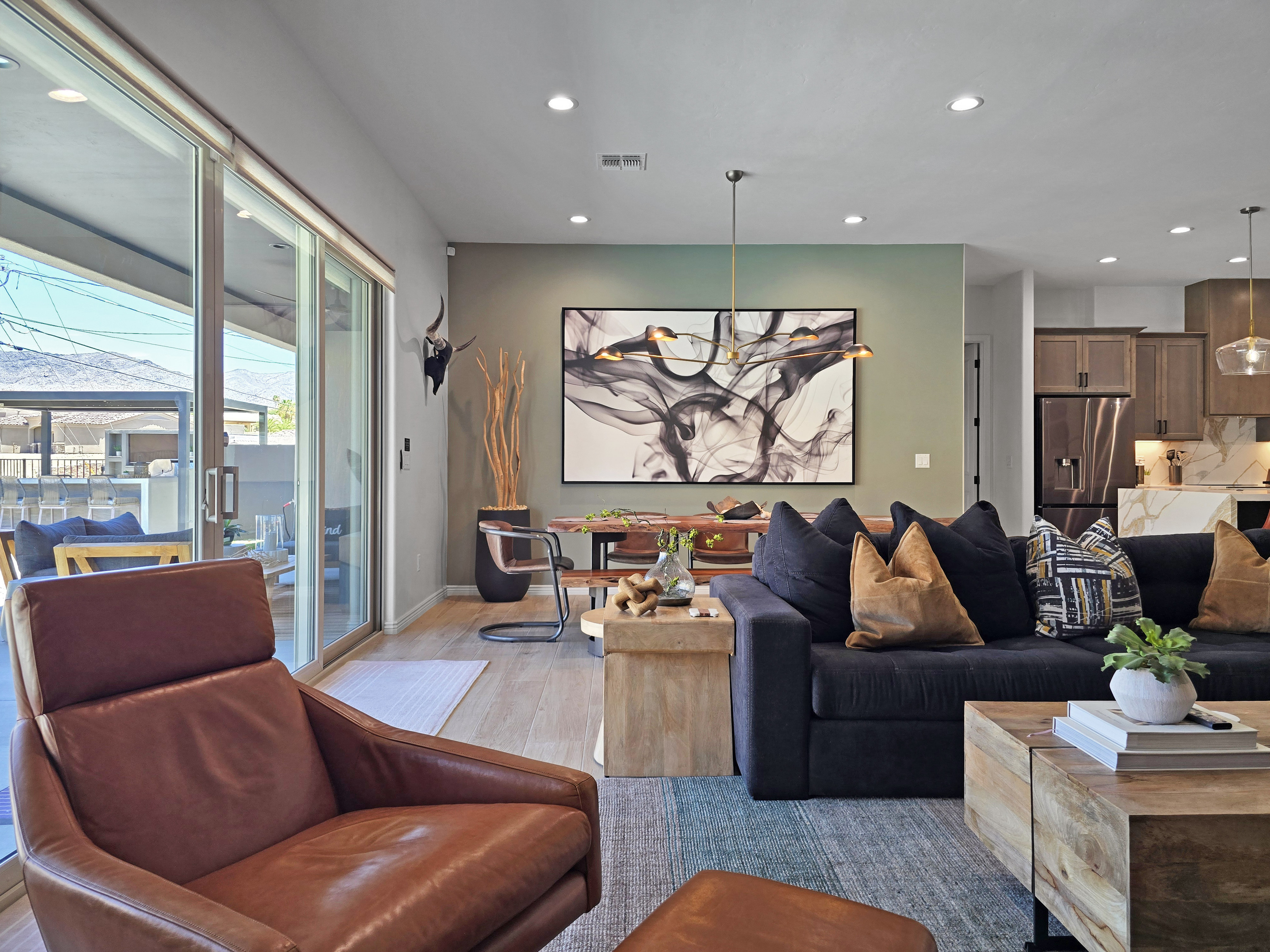 The living room flows seamlessly onto the outdoor patio, creating an effortless indoor-outdoor living experience.