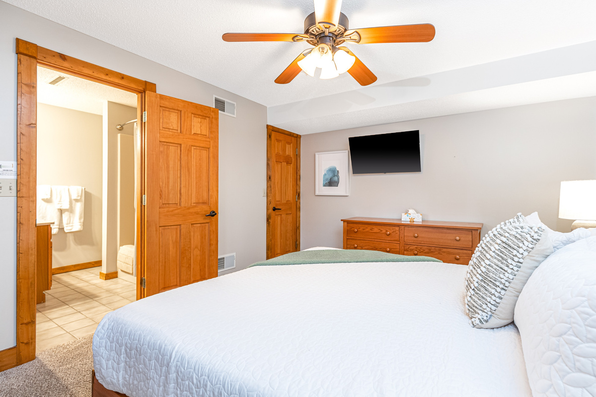 Bedroom 5 featuring a King bed and a Roku Smart TV, and an ensuite bathroom; one of three bedrooms located on the lower level.