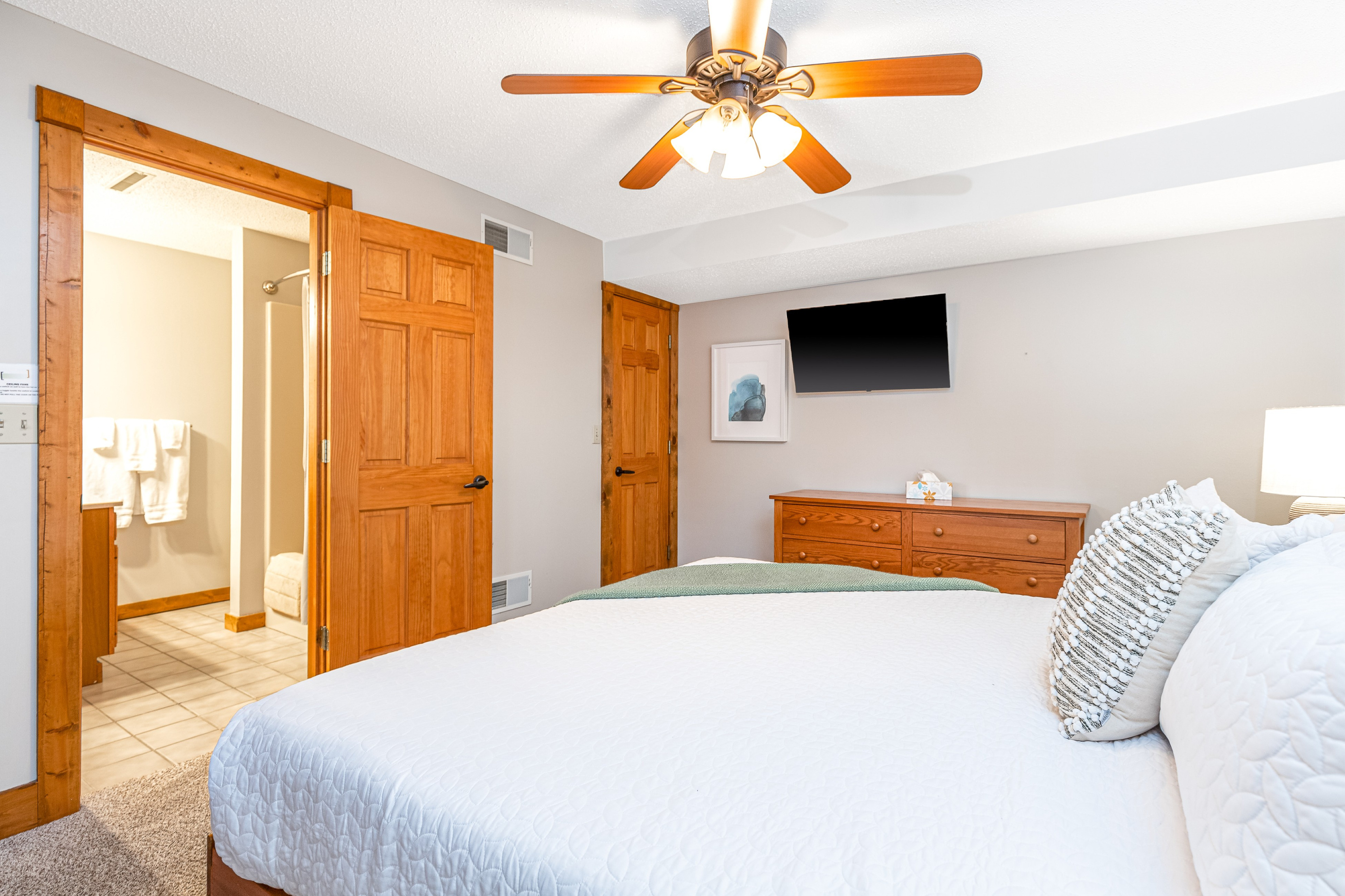 Bedroom 5 featuring a King bed and a Roku Smart TV, and an ensuite bathroom; one of three bedrooms located on the lower level.