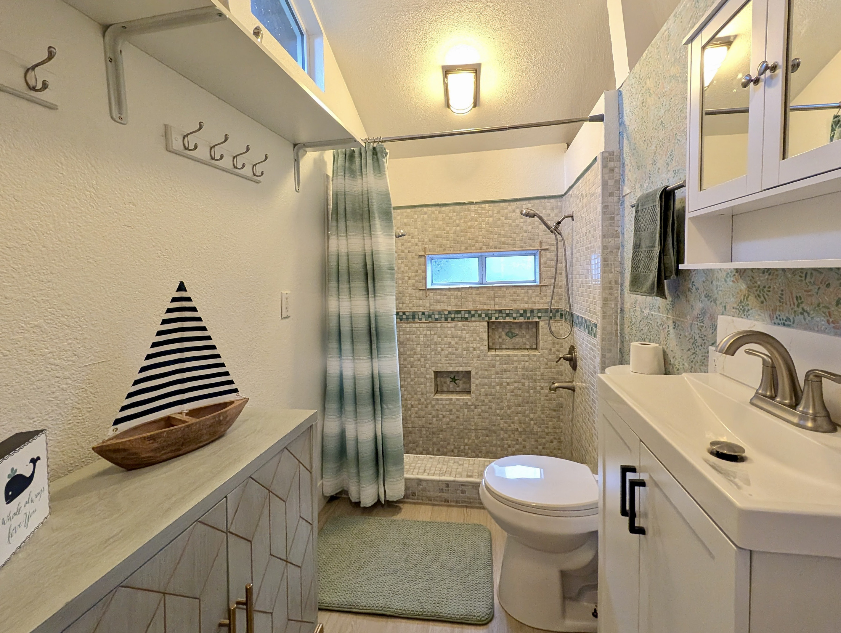 Thoughtfully designed with a large walk-in shower, modern vanity, and plenty of storage, this bathroom combines style and convenience for a comfortable stay.