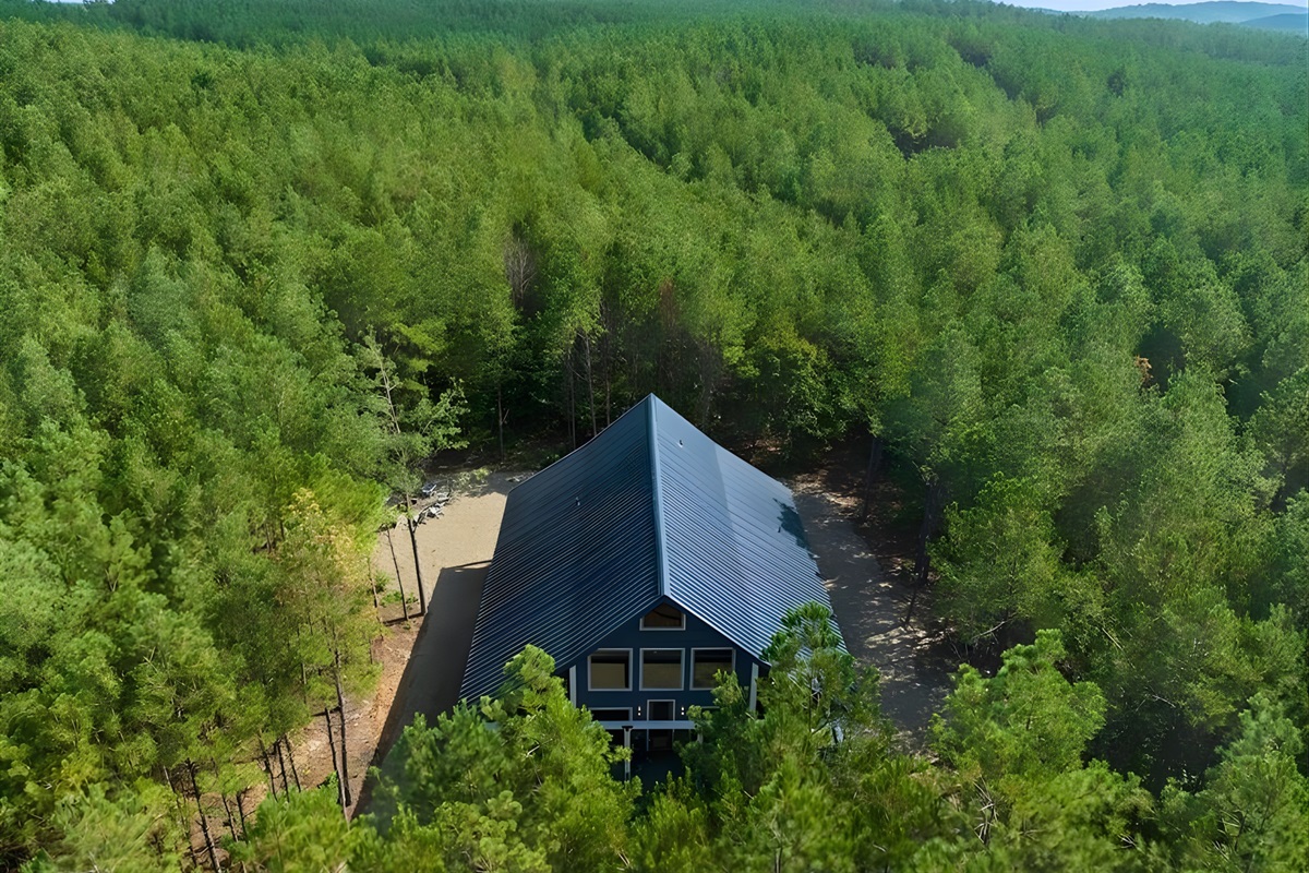 From above, the aerial view shows just how beautifully the cabin is nestled in a sea of green trees.
