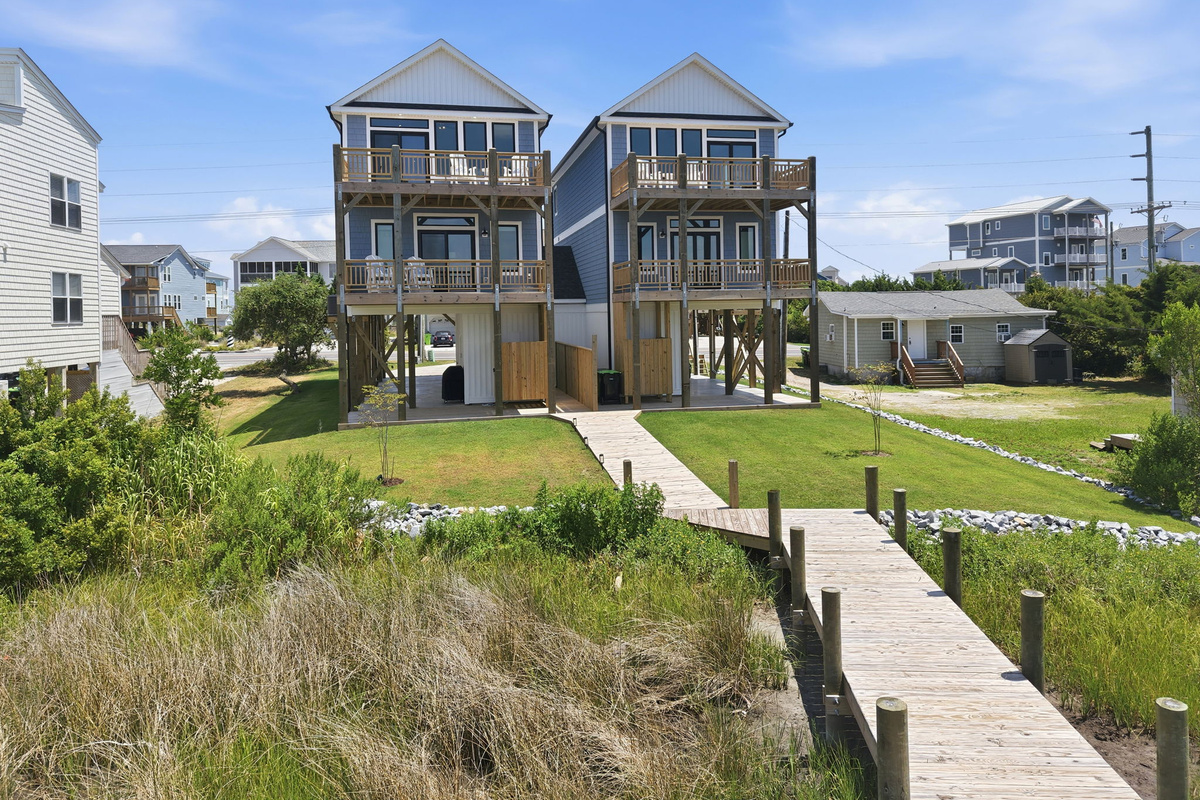 The private boardwalk leads from the backyard across the marsh to a dock, creating the perfect spot to enjoy waterfront views