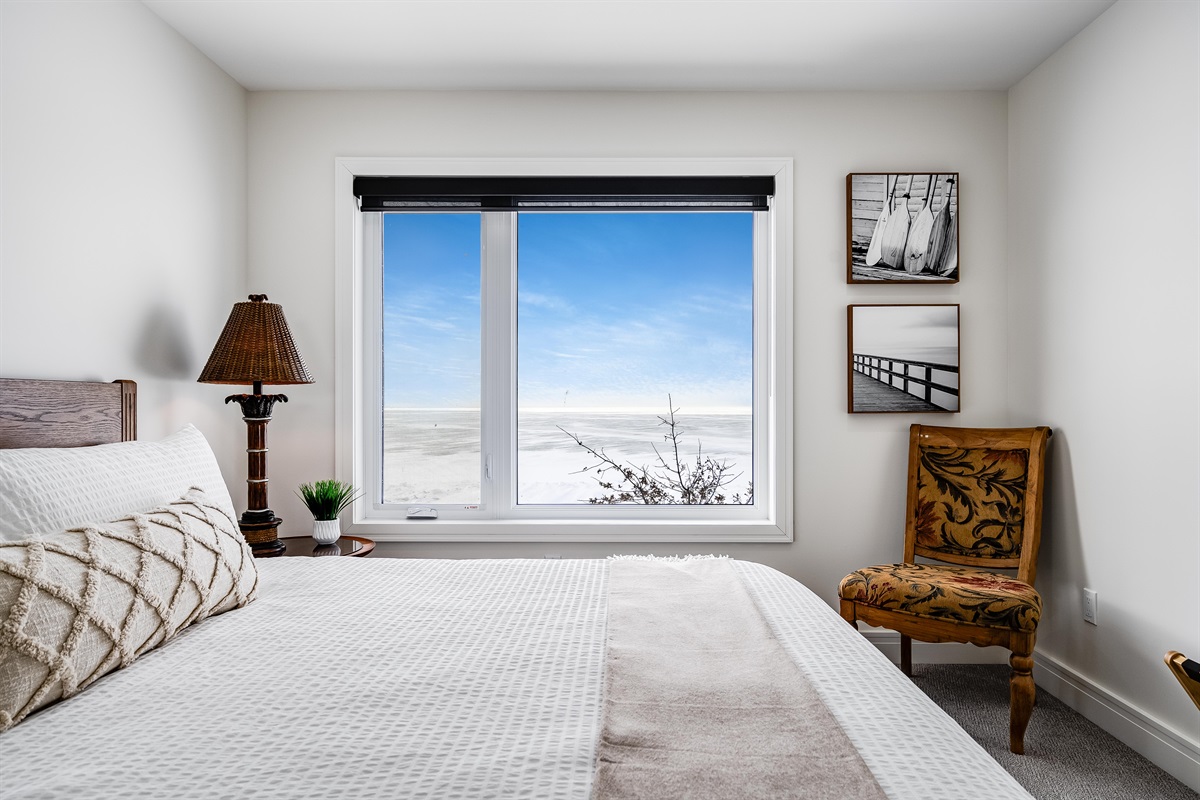 King bedroom with, Natural wood bed frame grounds the space.