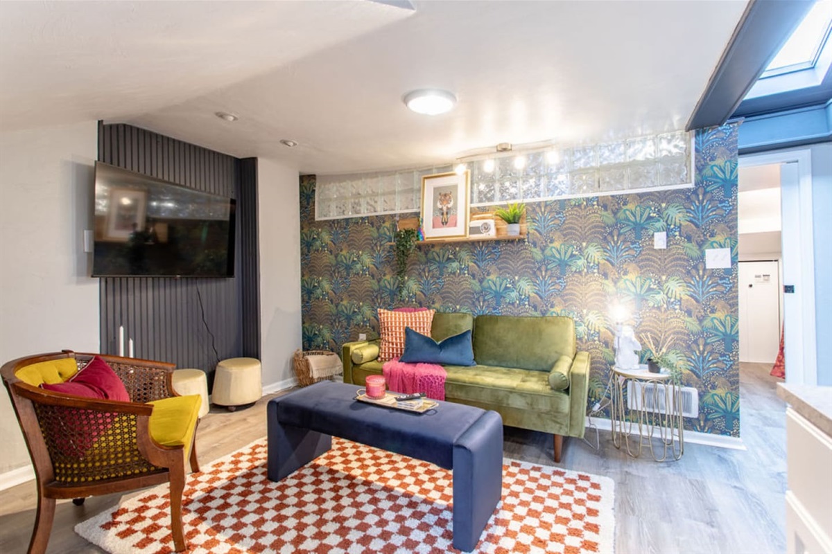 Step into this chic and vibrant living room, designed for ultimate comfort and relaxation. Sink into the stylish seating, catch up on your favorite shows on the 55-inch Roku TV, and enjoy the unique, colorful decor that adds a touch of flair. The roo