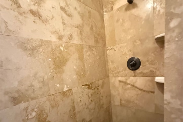 Travertine tile walk in shower. So beautiful we replicated it in the other townhouse.