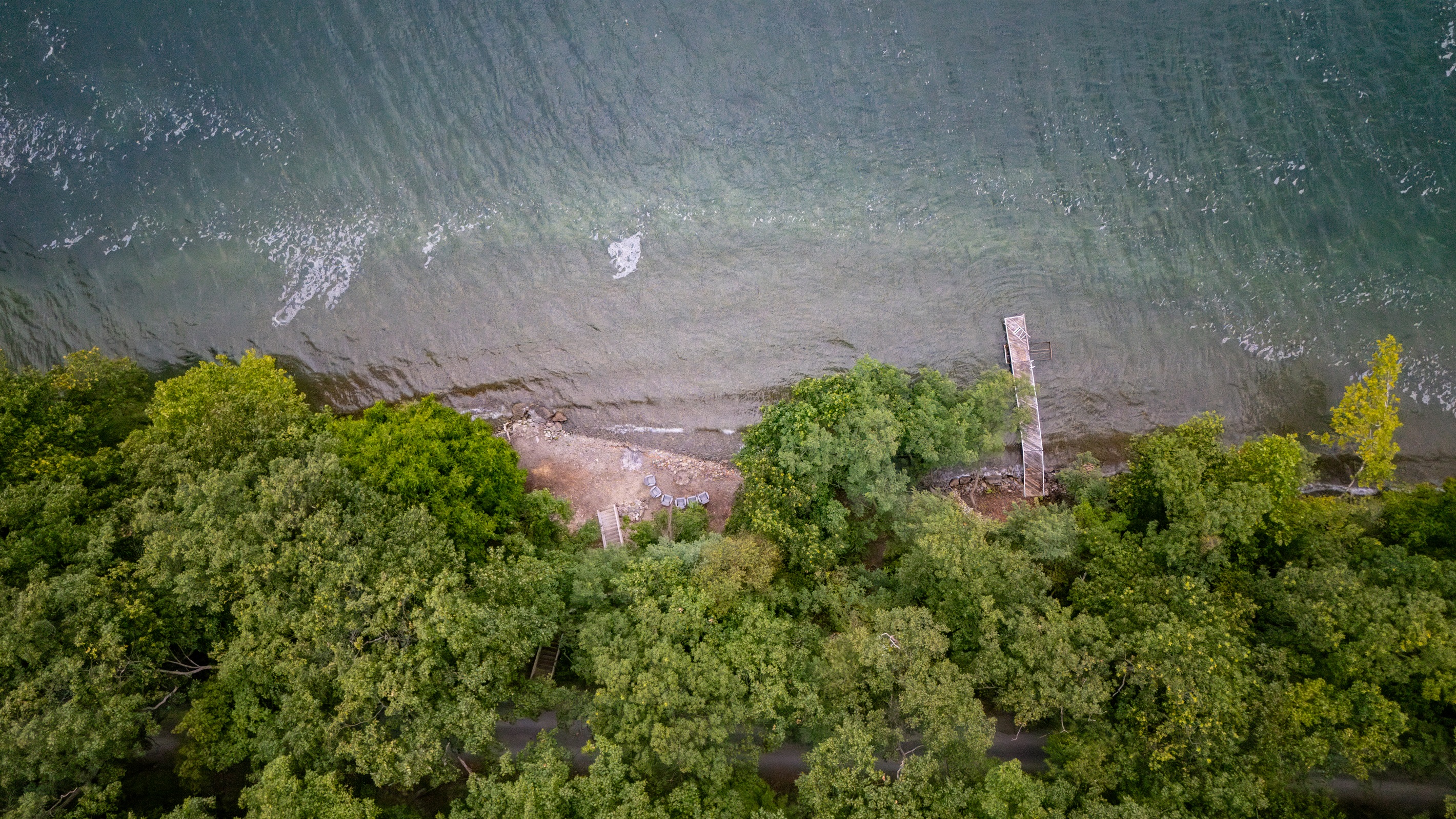 Stunning aerial perspective showcasing lakefront homes with private docks, sandy shoreline, and breathtaking Finger Lakes scenery.