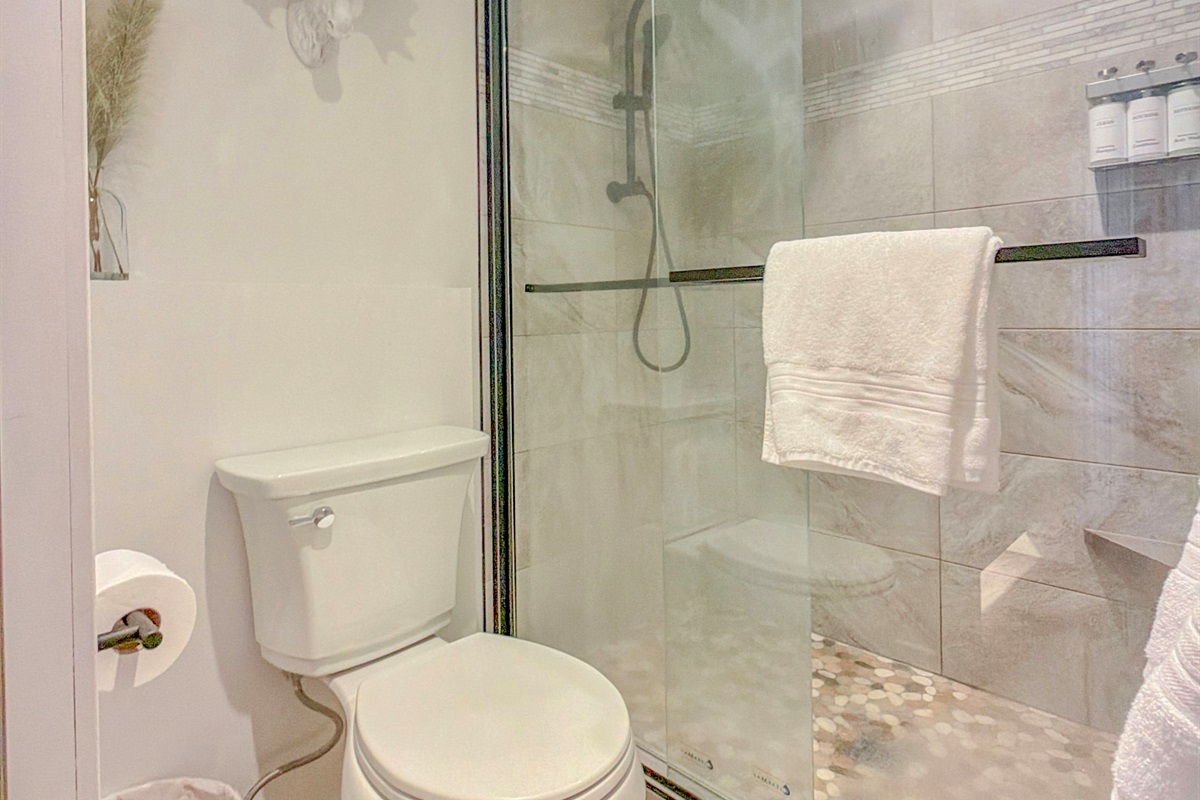 Enjoy a bright, updated bathroom featuring custom tiled shower, with relaxing rain shower feature.