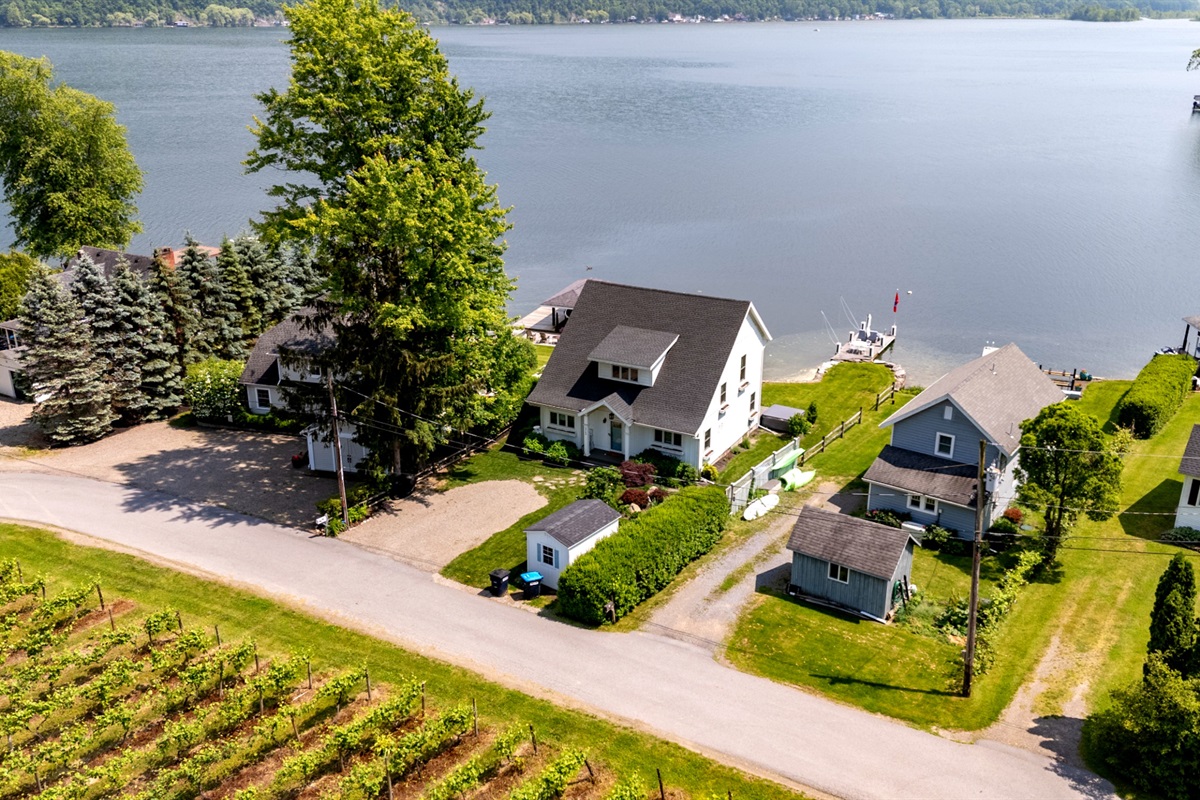 Stunning aerial view of a serene Finger Lakes waterfront retreat, complete with private dock, lush greenery, and charming lakefront homes—perfect for peaceful getaways and water adventures