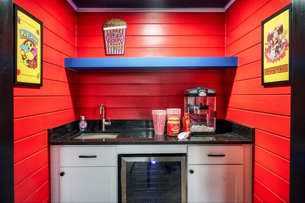 Game room wet bar with wine fridge + retro popcorn machine — the ultimate movie night setup.