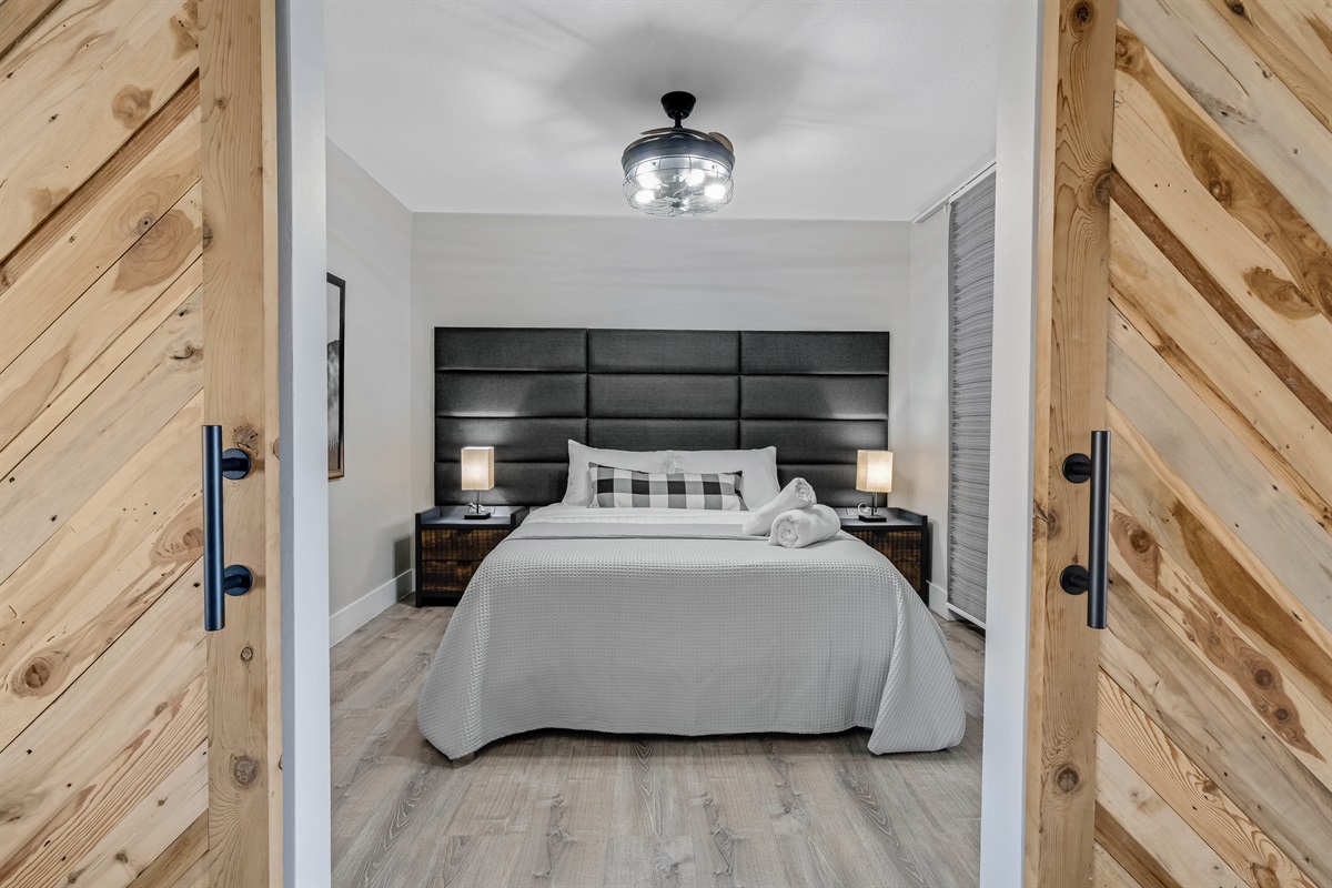 🛌 Cozy queen room with clean lines and easy access to the shared bath.