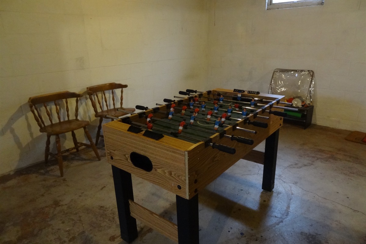 Foosball table and extra chairs in basement