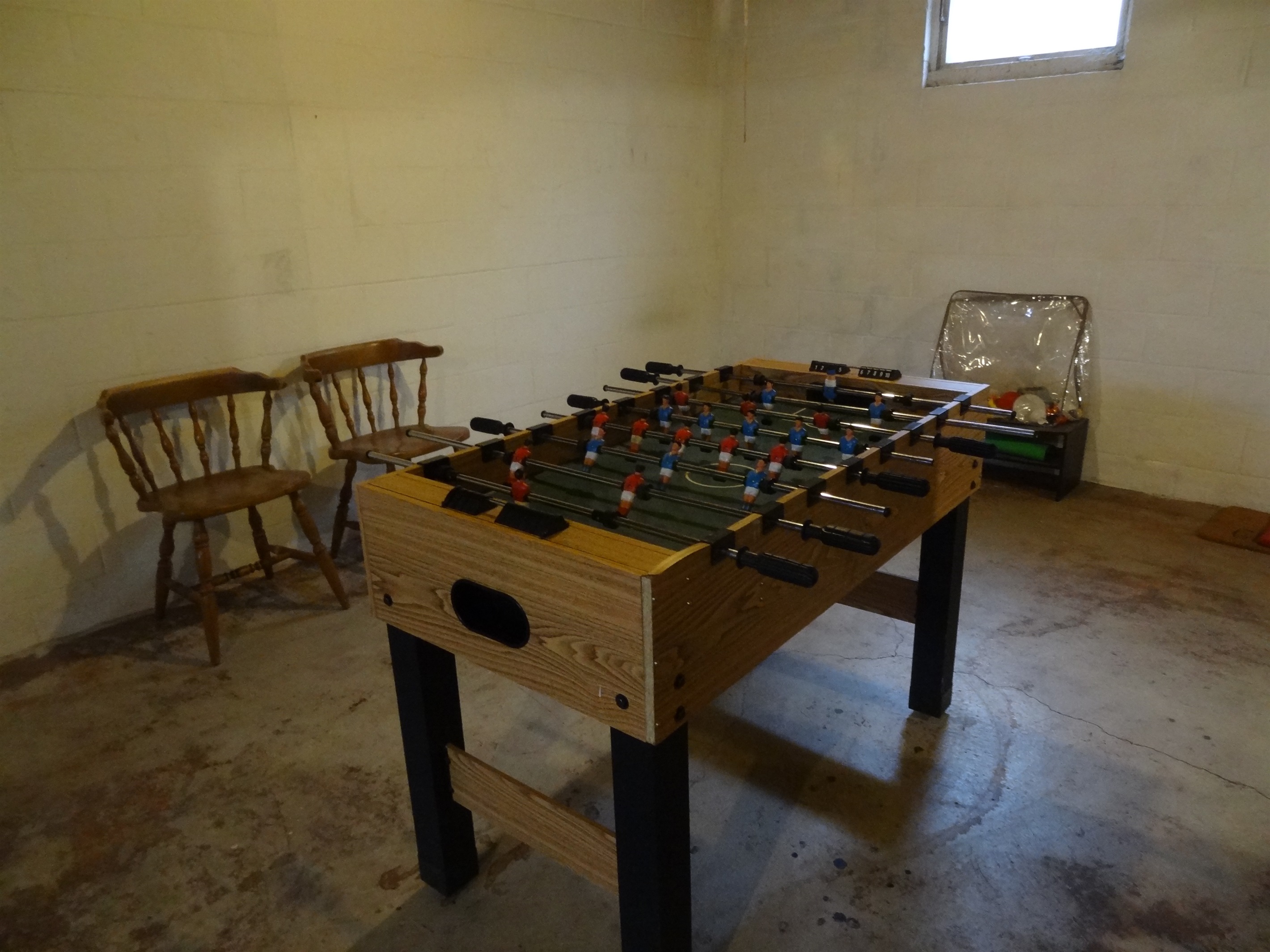 Foosball table and extra chairs in basement