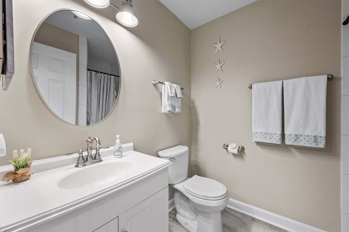 Modern and well maintained Master bathroom 2, featuring clean finishes, quality towels, and beachy accents