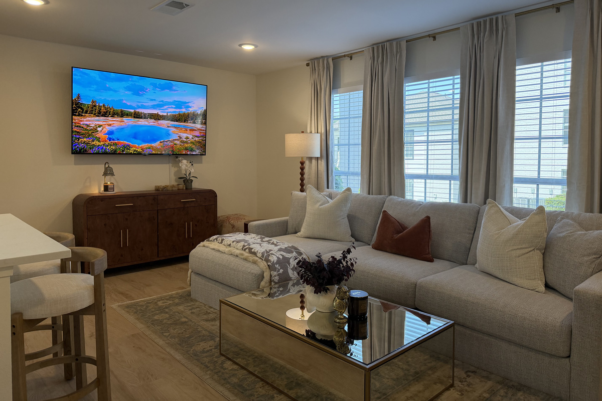 Sink into the deep sectional under a wall of windows, with navy and rust pillows in the house colors.