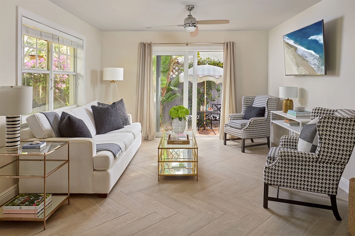 Cottage - Relax in this light-filled, spacious living room, thoughtfully designer-appointed for comfort and style. Enjoy the cozy Queen sofa sleeper, a 60” smart TV, and expansive windows that overlook the serene private patio, creating a peaceful retreat.