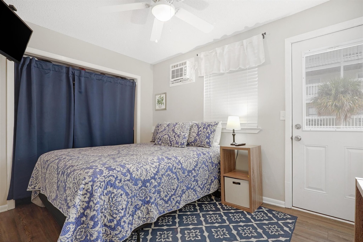 Bedroom - The cozy bedroom features Queen bedding, mounted television, and balcony access.