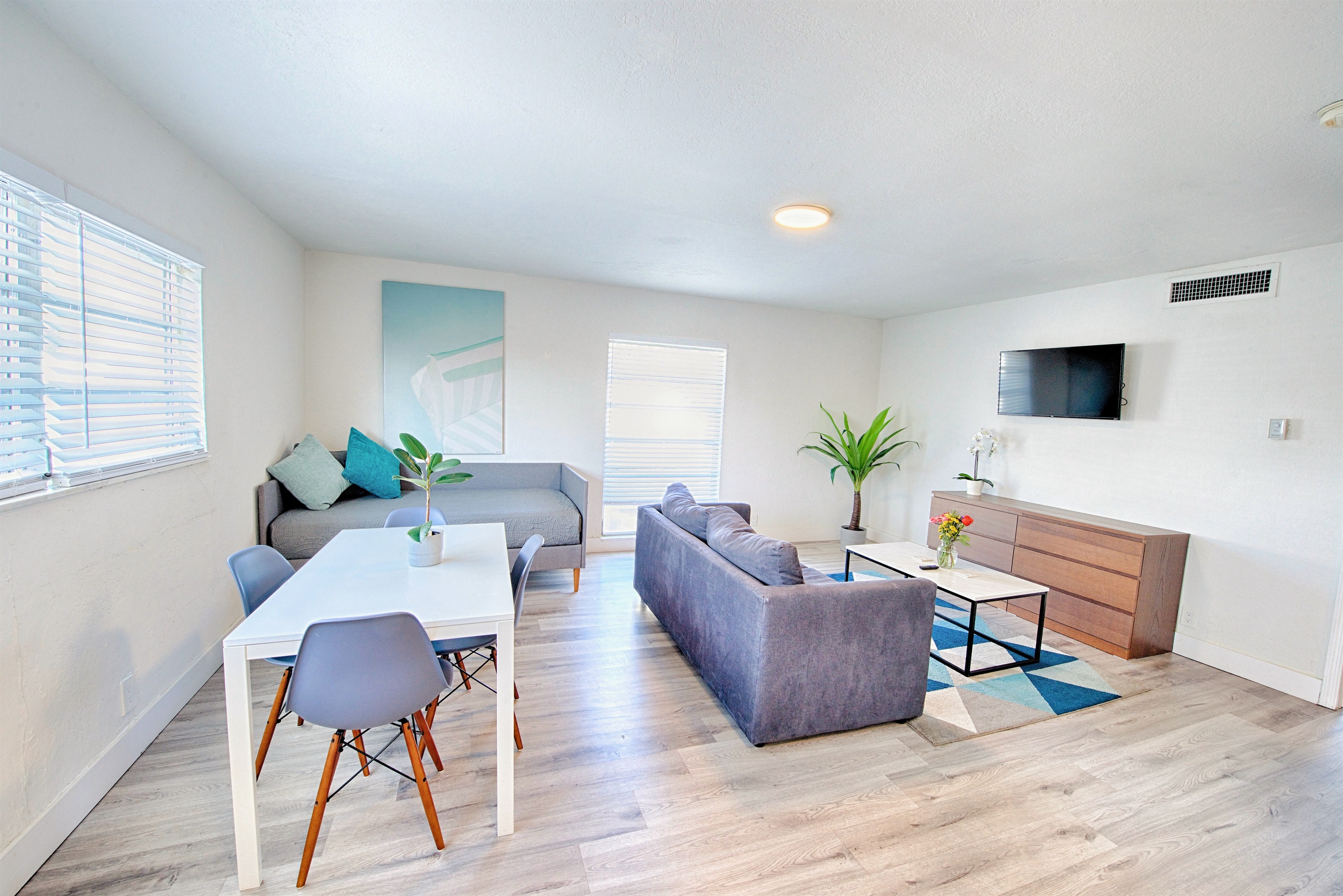 View showing day bed, dining table, sofa (with queen bed inside) and 40" smart TV
