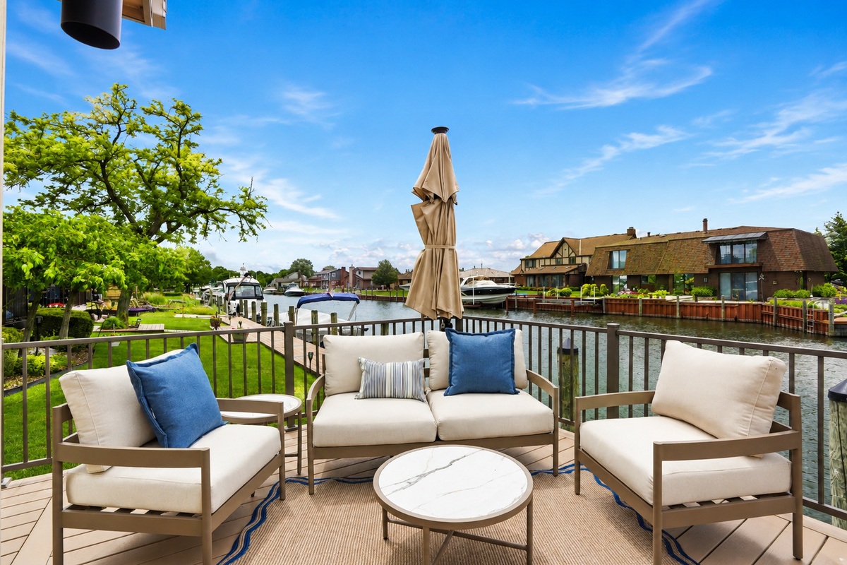 Relax on this private waterfront patio overlooking a peaceful canal. Enjoy comfortable lounge seating, umbrella shade, and serene water views—perfect for morning coffee or sunset drinks. A quiet, upscale outdoor retreat just steps from the water.