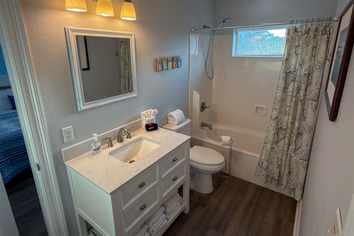 Jack-and-Jill Bathroom 3 offers a spacious shared layout with dual bedroom access, a full tub and shower combo, and bright coastal touches throughout.