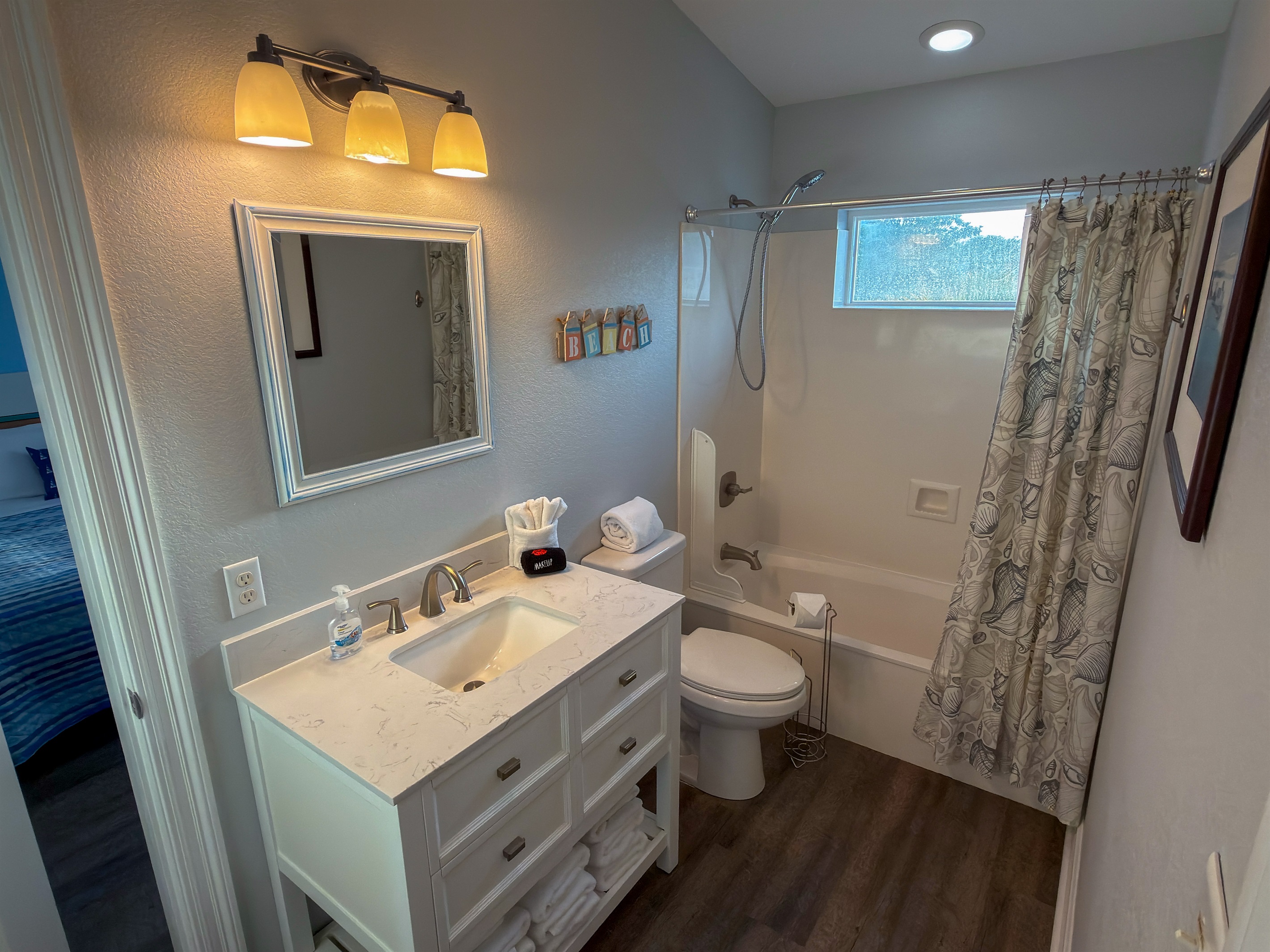 Jack-and-Jill Bathroom 3 offers a spacious shared layout with dual bedroom access, a full tub and shower combo, and bright coastal touches throughout.