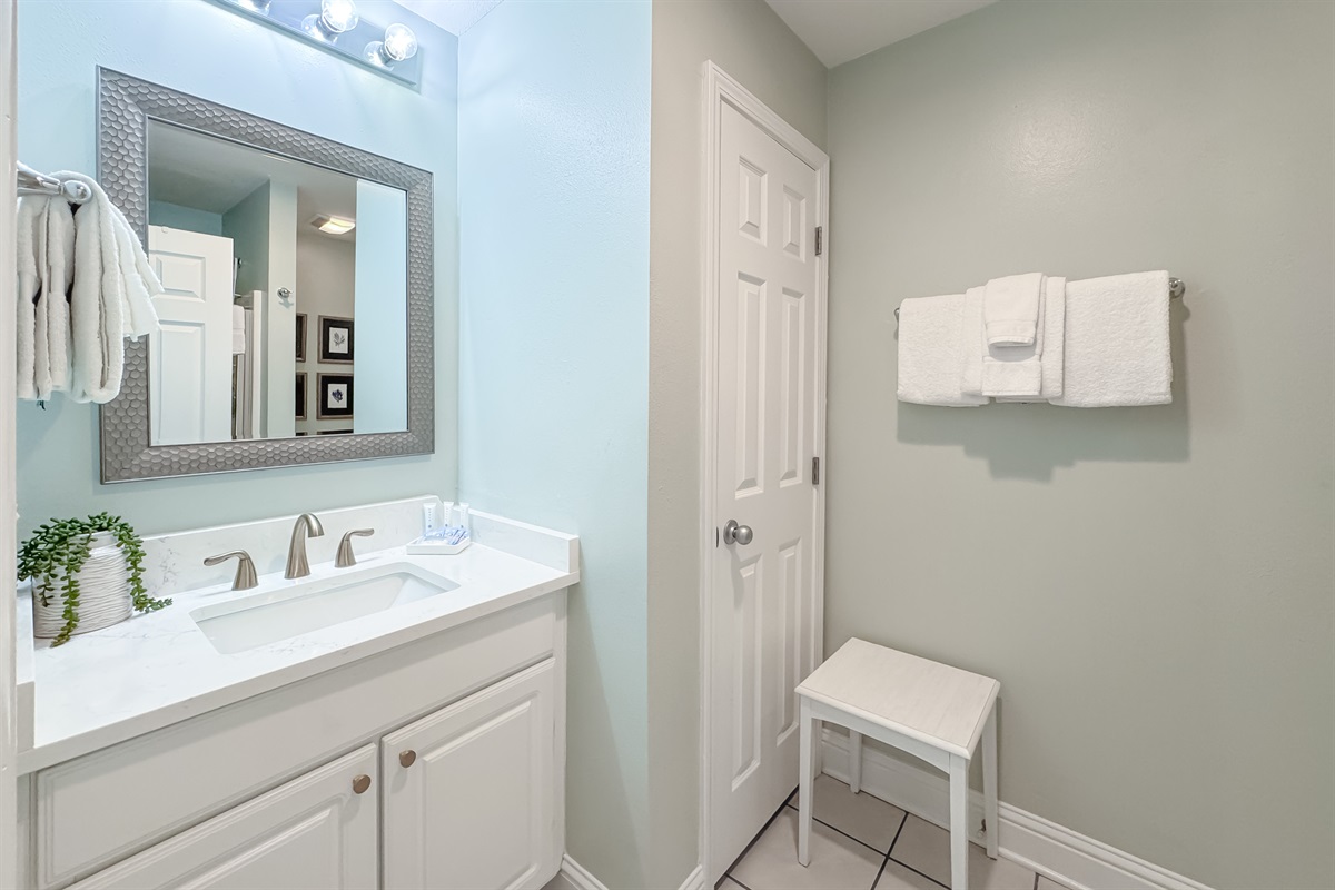 This well-lit guest bathroom offers ample space and essential amenities.  A clean and inviting retreat.