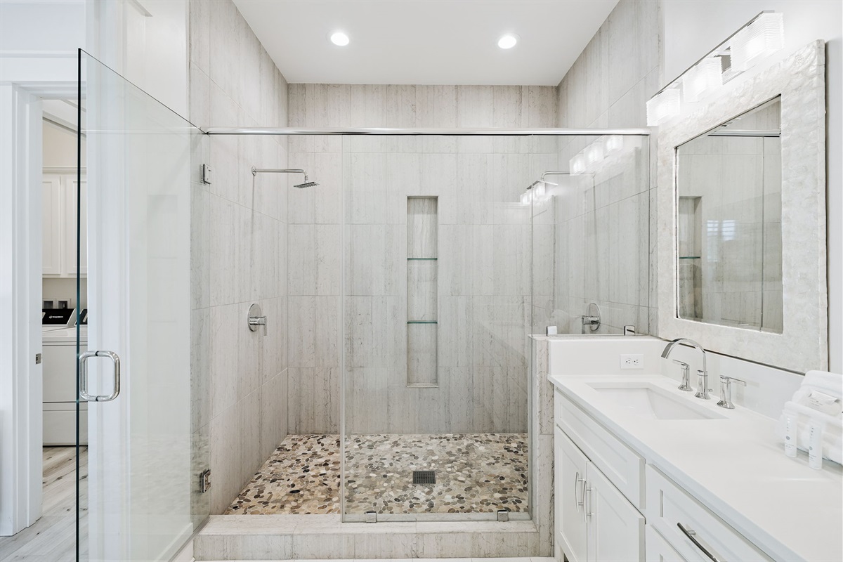 Second floor master ensuite bathroom with double vanities and an oversized shower featuring dual shower heads.