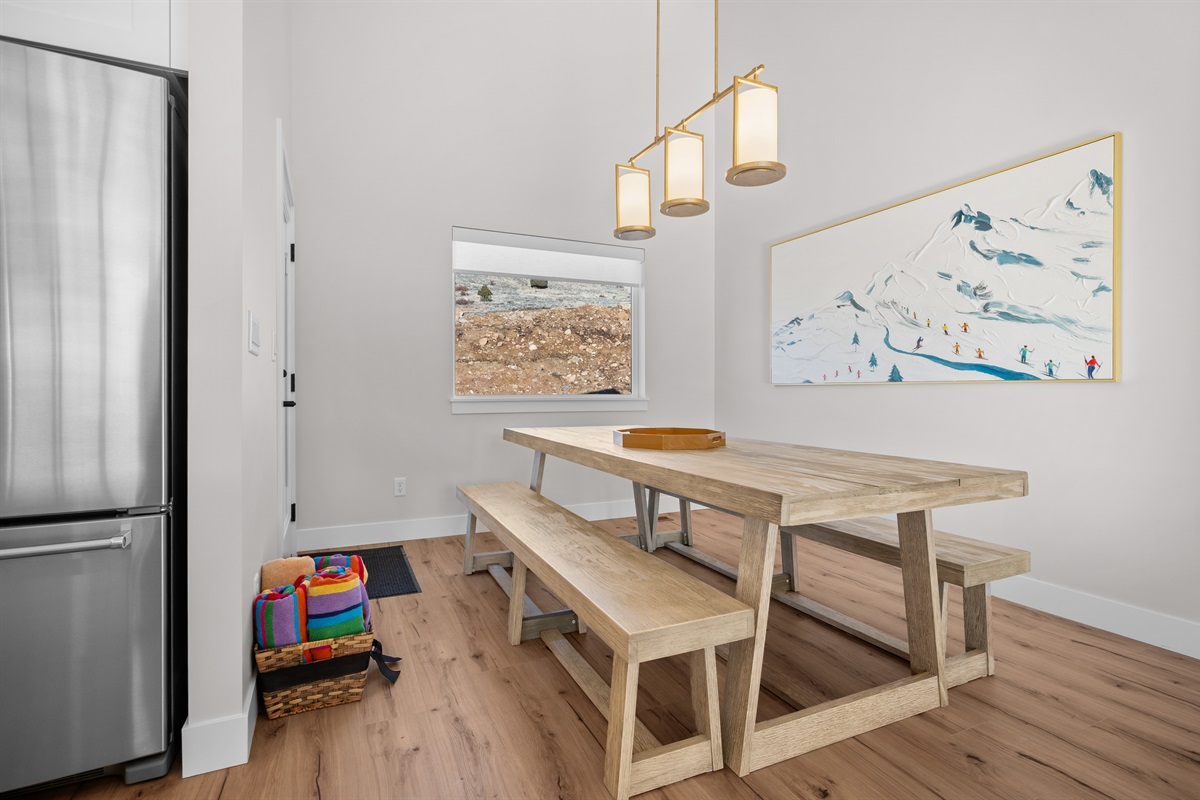 Dining area with rustic wood table and bench seating, framed by scenic Ogden Valley views.