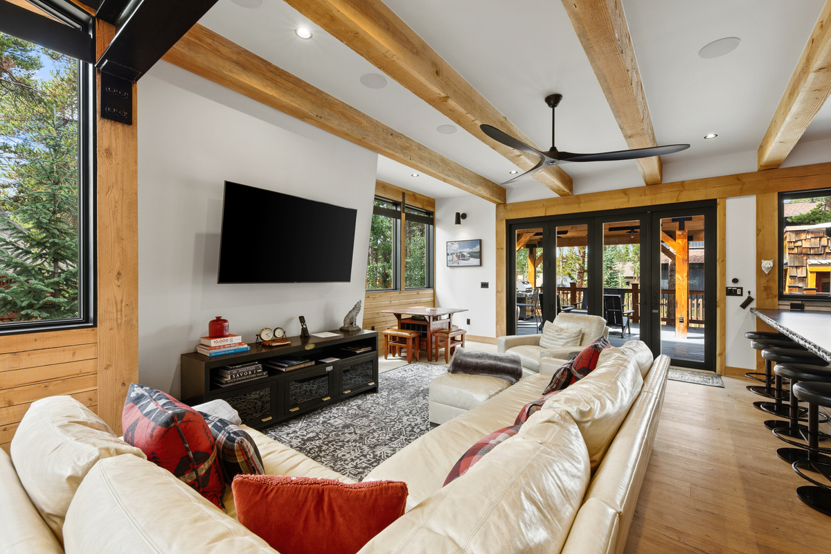 Living area with leather sectional sofa next to bar seating in kitchen