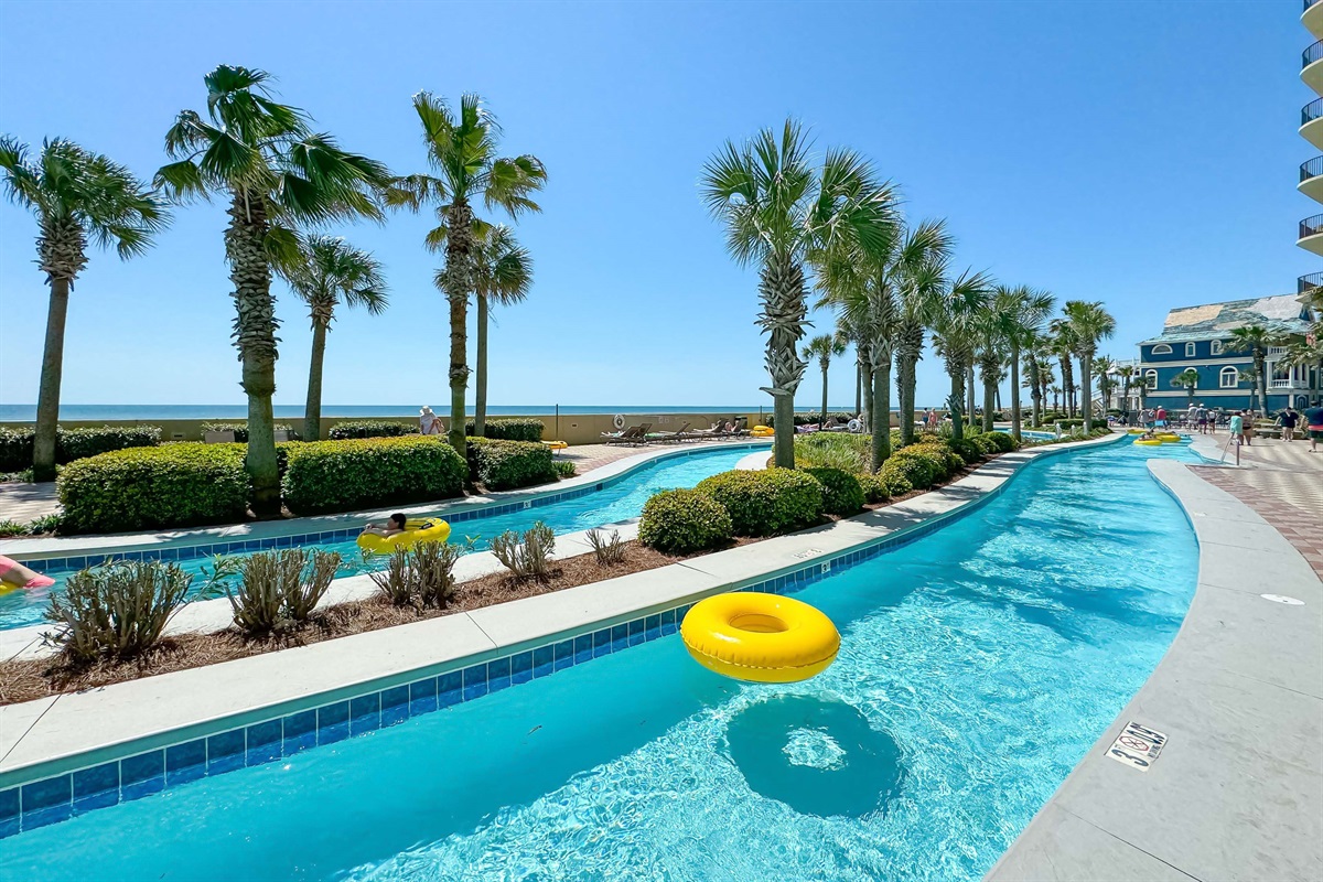 Enjoy the scenic lazy river at Phoenix West, surrounded by palm trees and coastal views—an ideal home getaway featuring premium amenities and direct beach access.