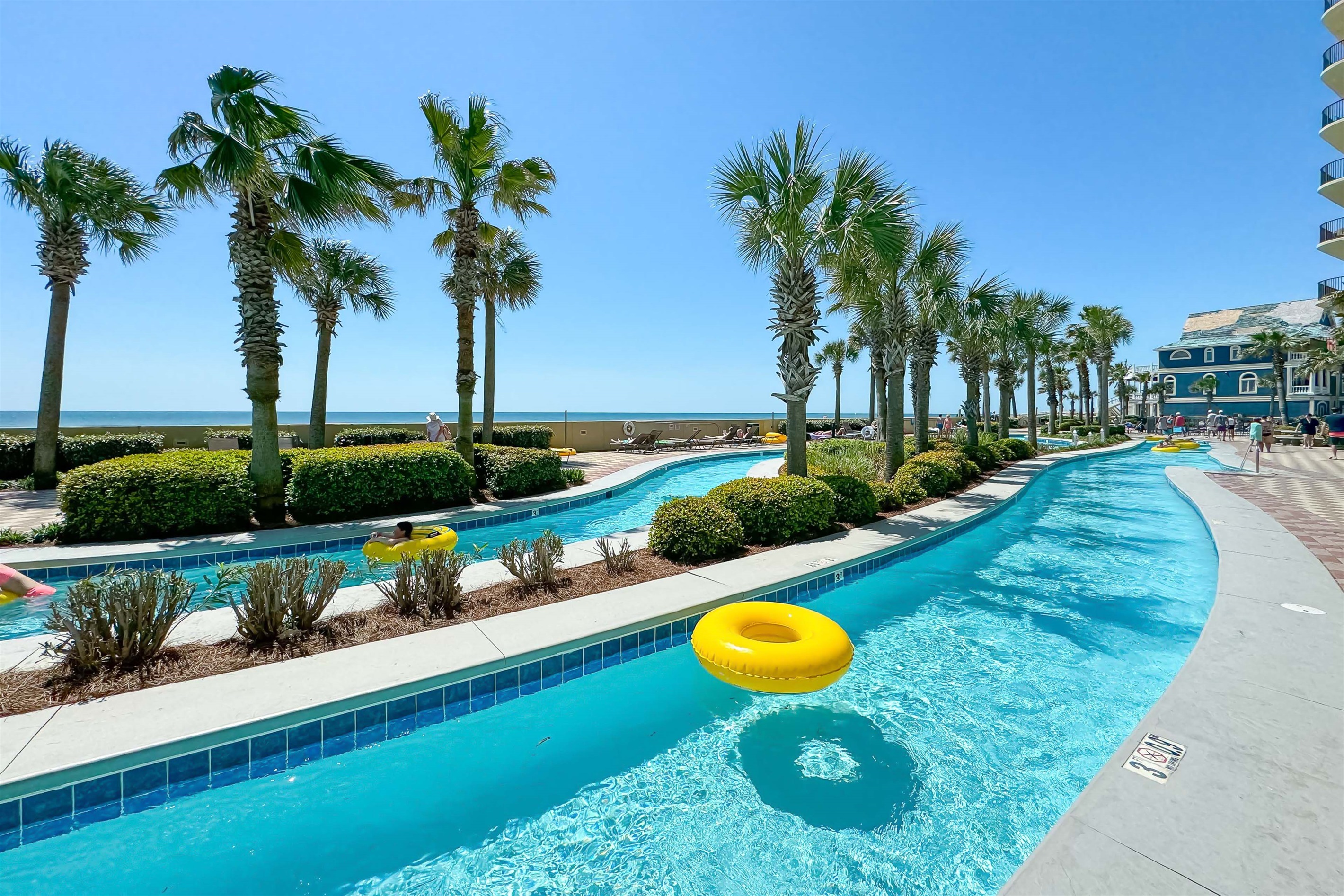 Enjoy the scenic lazy river at Phoenix West, surrounded by palm trees and coastal views—an ideal home getaway featuring premium amenities and direct beach access.