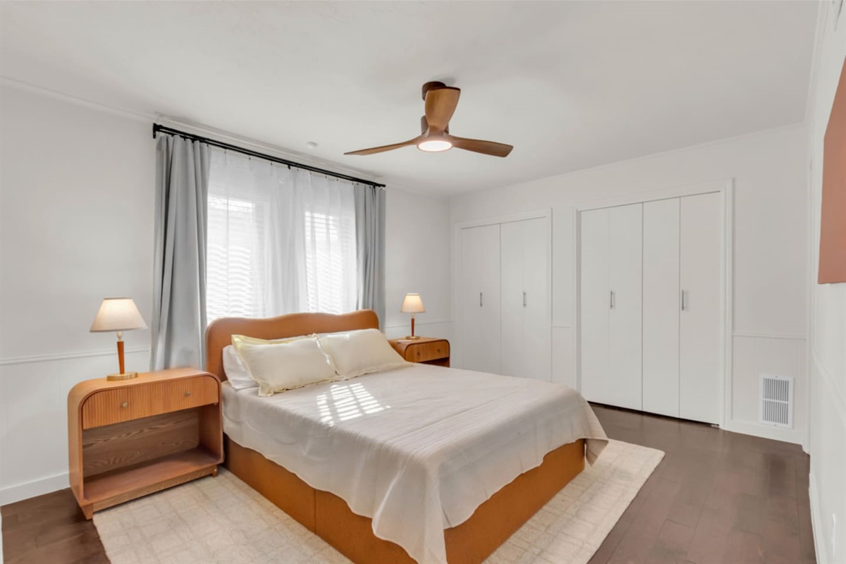 Guest bedroom with a queen bed, room-darkening shades, comfy bed, and a closet for comfortable and organized stays.