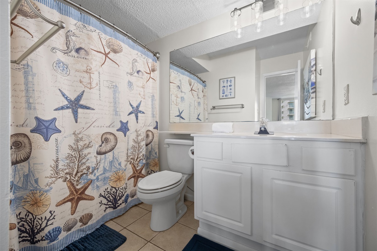 Full ensuite bathroom with shower and coastal themed touches for a relaxing refresh