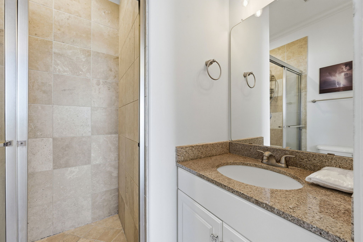 Clean coastal bathroom with modern finishes and a walk-in shower designed for easy beach days