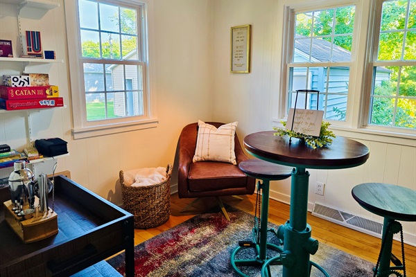 A nook for every mood—morning brews at the high table, quiet escapes in the reading chair, and shelves of stories, games, and sips to end the day.