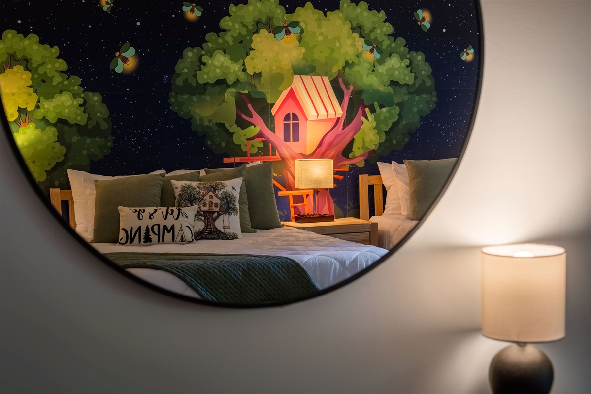 A playful treehouse mural reflected in a cozy corner—perfect for sparking imaginations before bedtime.