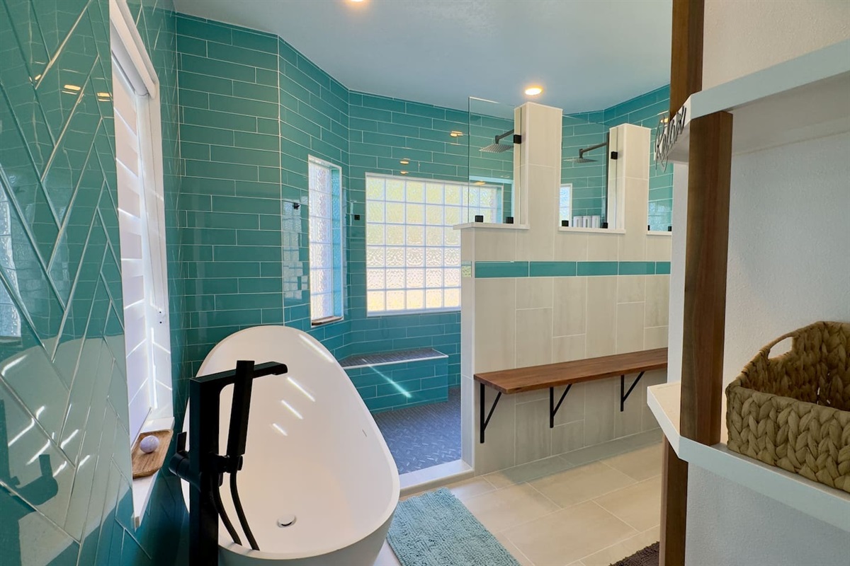 Teal subway tiles and a textured glass block window create a bright, private, and refreshing atmosphere.